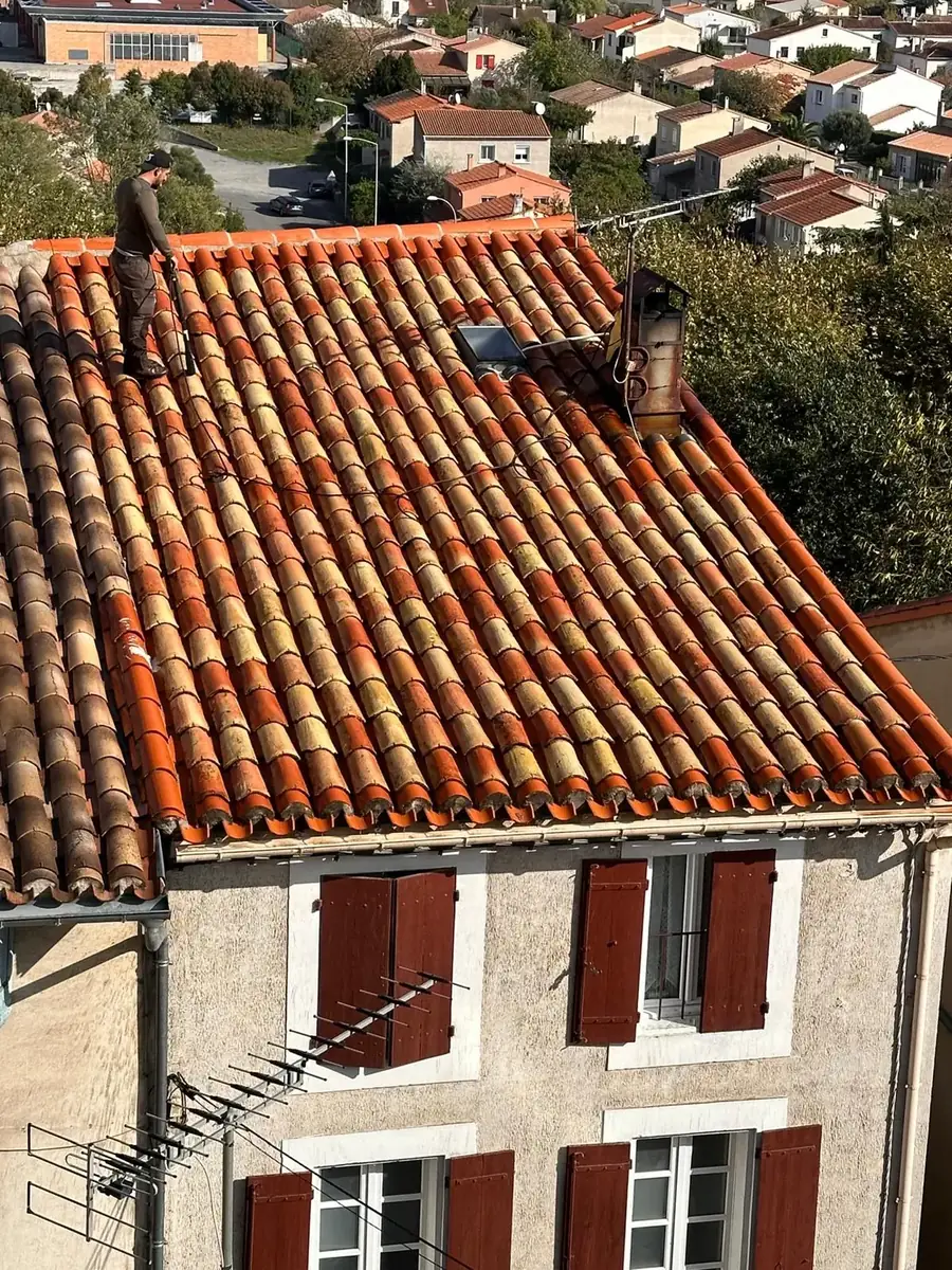 Toit en tuiles canal vu de haut, maison à volets rouges